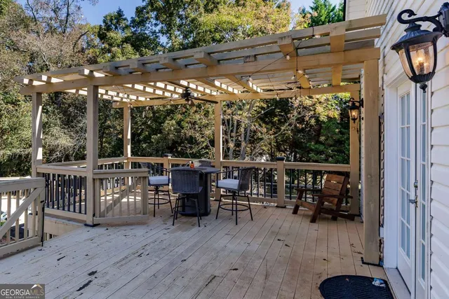 a view of a patio with table and chairs and barbeque with wooden fence