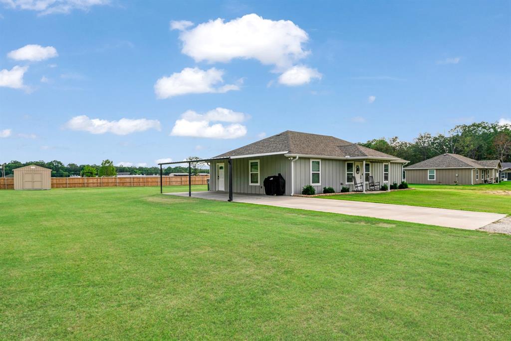 21 Private Road Paris, TX 75462 - Photo 2 of 15 Back of property with board and batten siding, a shed, and roof with shingles