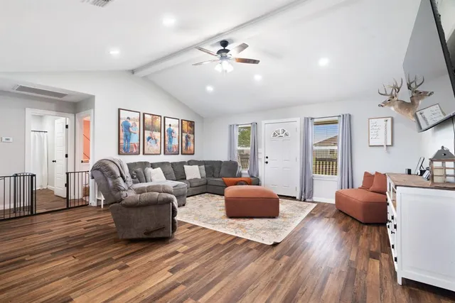 a living room with furniture and a wooden floor