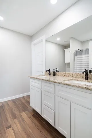 a bathroom with double vanity sink and mirror