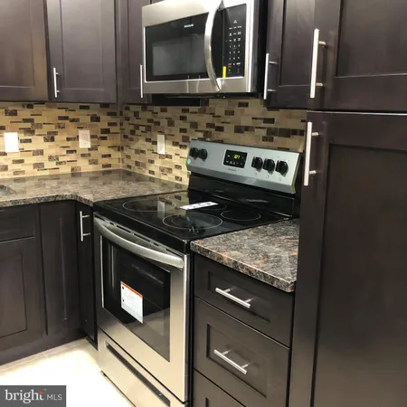 a kitchen with granite countertop stainless steel appliances and cabinets