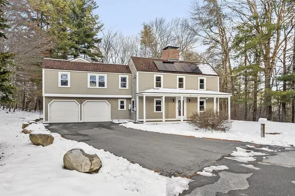 a front view of a house with a yard covered with snow