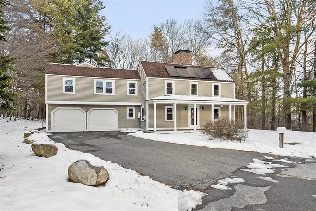 a front view of a house with a yard covered with snow