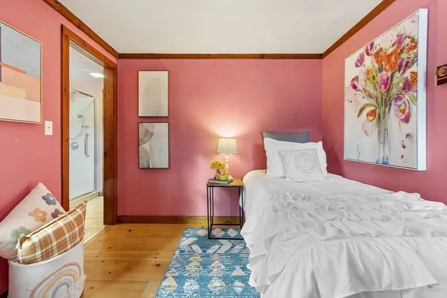 a bedroom with a bed and a painting on the wall
