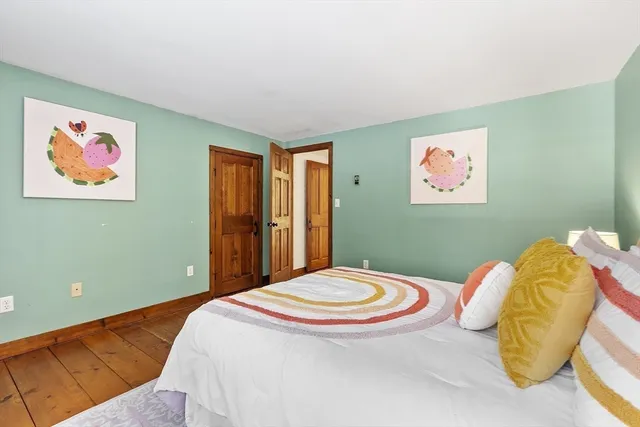 a bedroom with a bed and a painting on the wall