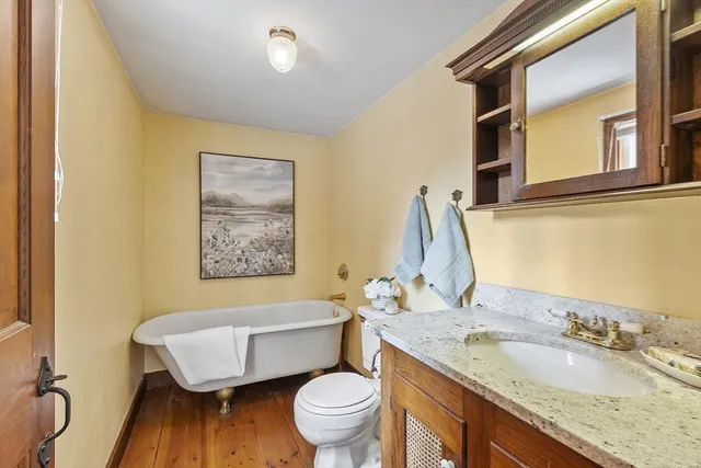 a bathroom with a granite countertop toilet sink and mirror