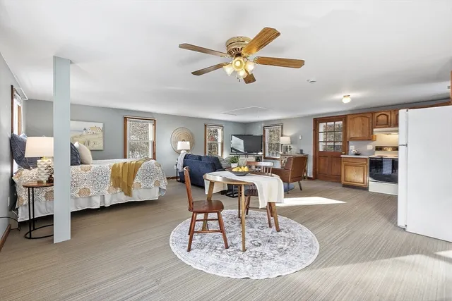 a living room with furniture kitchen view and a chandelier