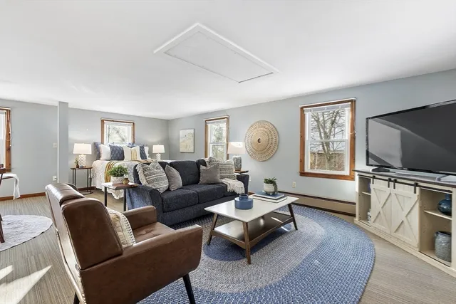 a living room with furniture a window and a flat screen tv