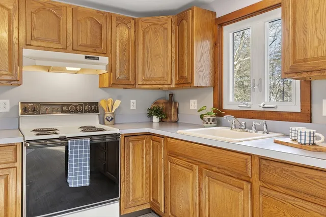 a kitchen with stainless steel appliances granite countertop a sink a stove and cabinets