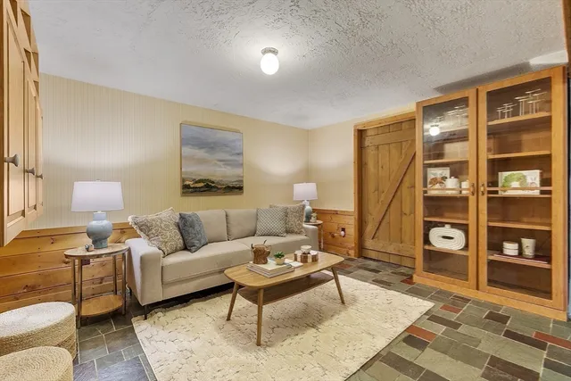 a living room with furniture a rug and a bookshelf
