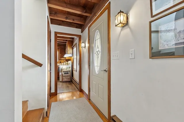 a view of a hallway with wooden floor and staircase