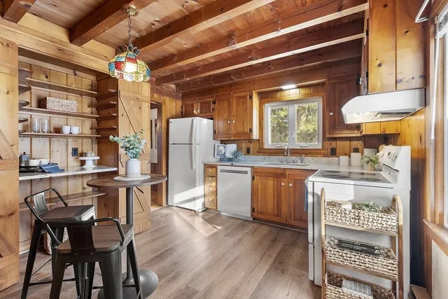 a kitchen with refrigerator a stove and wooden floor