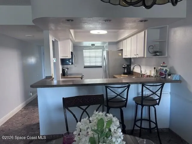 a kitchen with stainless steel appliances a table chairs and a refrigerator