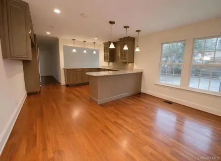 a large kitchen with stainless steel appliances granite countertop a large window