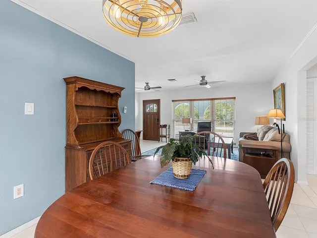 a dining room with furniture a chandelier and wooden floor