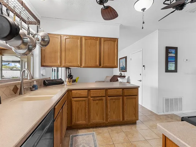 a kitchen with a sink dishwasher a stove a microwave oven with a dining table and chairs