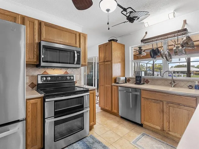 a kitchen with stainless steel appliances a stove sink and microwave