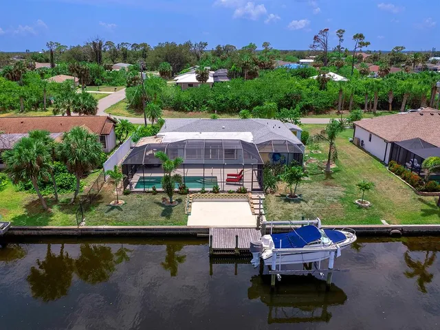 an aerial view of a house with swimming pool and a yard