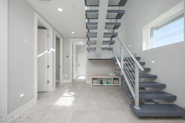 a living room with furniture a wooden floor and a large window