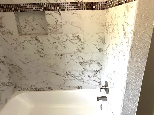 a bathroom with a bathtub and shower