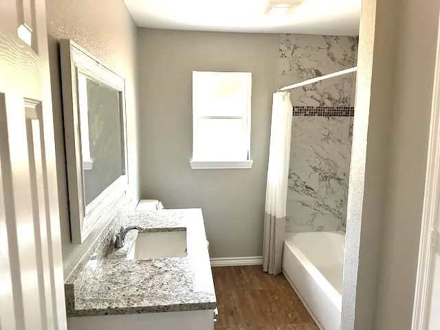 a bathroom with a tub sink and glass door