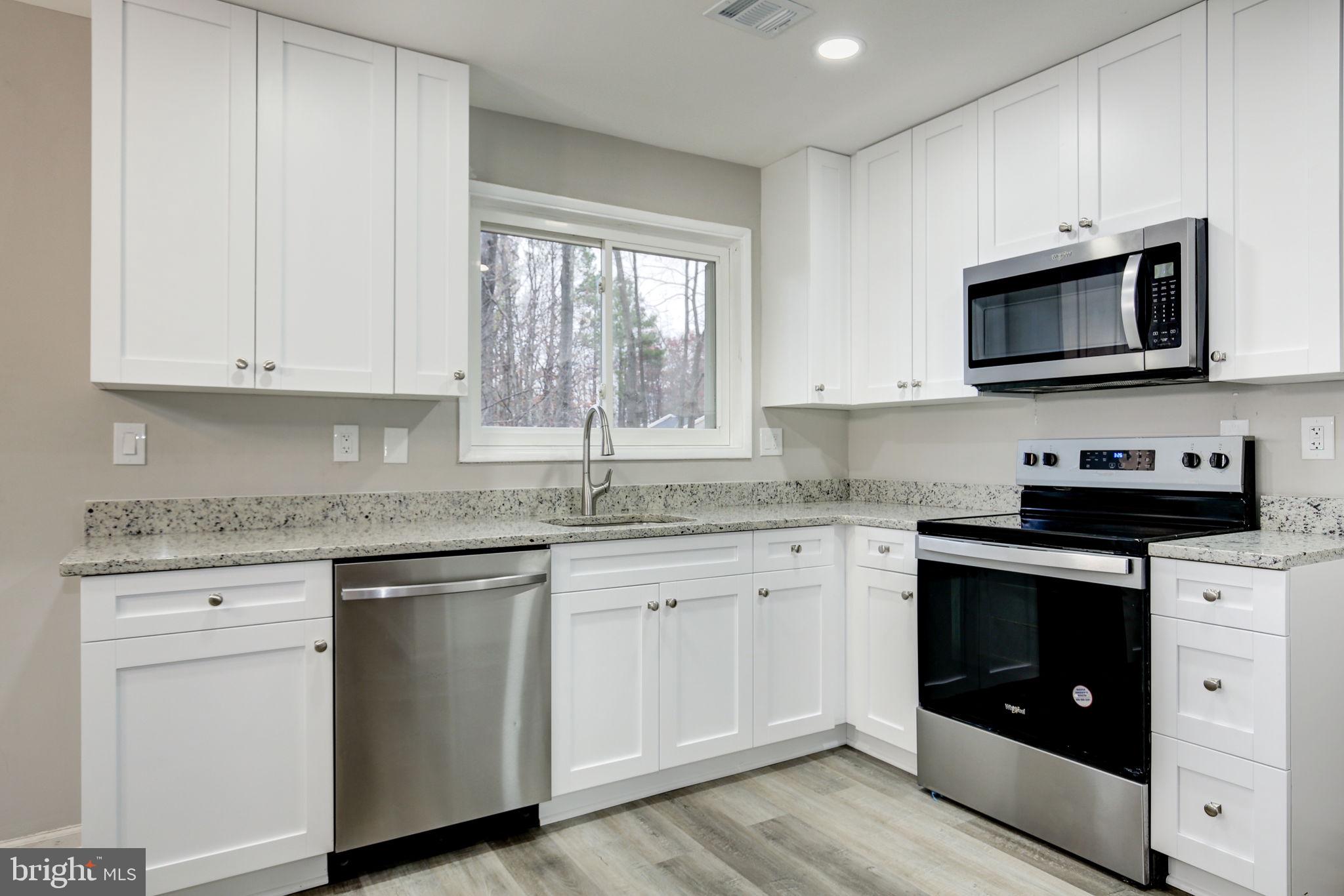 2394 Southgate Square Reston, VA 20191 - Photo 13 of 58 a kitchen with stainless steel appliances granite countertop a stove a sink and a microwave