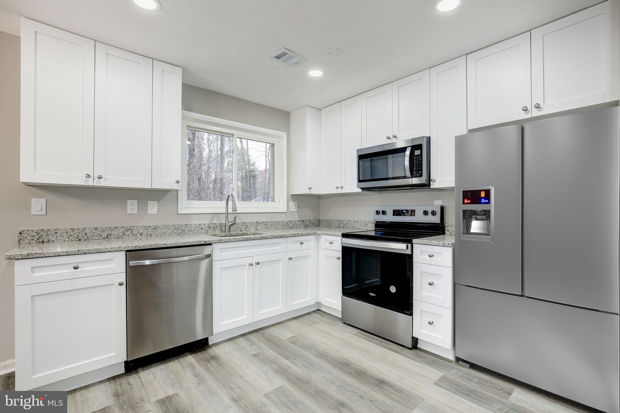 2394 Southgate Square Reston, VA 20191 - Photo 15 of 58 a kitchen with granite countertop white cabinets and stainless steel appliances