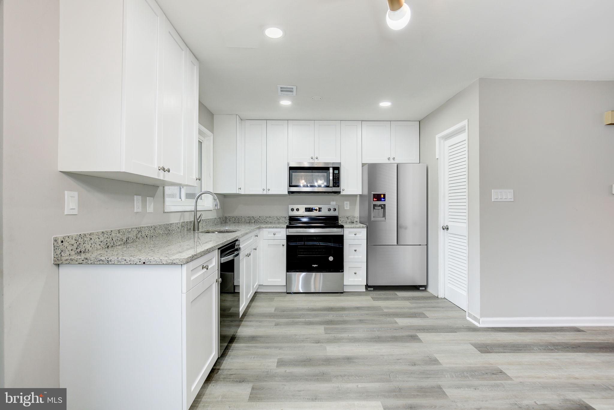 2394 Southgate Square Reston, VA 20191 - Photo 16 of 58 a kitchen with stainless steel appliances granite countertop a stove top oven a refrigerator and a granite counter tops with white cabinets
