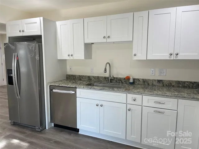 a kitchen with white cabinets and stainless steel appliances
