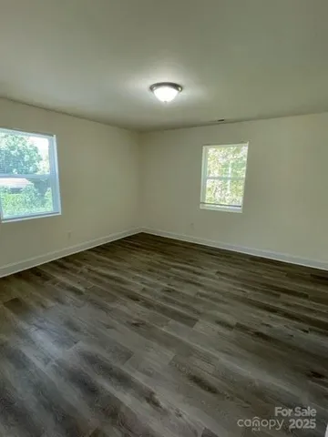 a front view of a house with a garden and trees