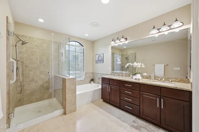 a spacious bathroom with a bathtub shower sink mirror and