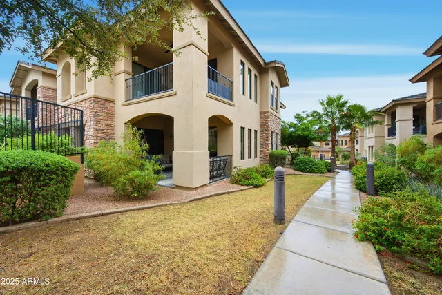a front view of a house with a yard and potted plants