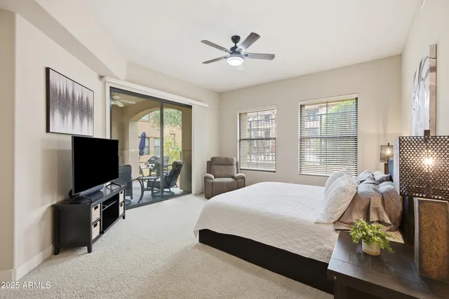 a bedroom with a bed and a flat tv screen on the dresser