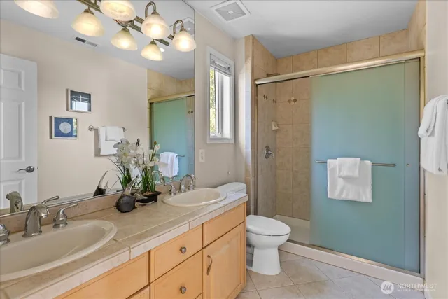 a bathroom with a granite countertop sink a toilet and a mirror