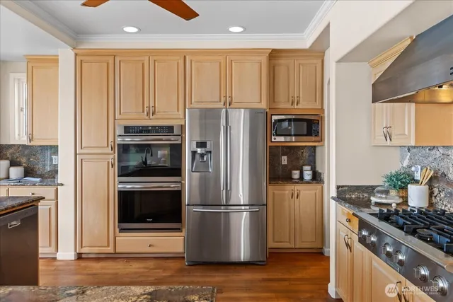a kitchen with stainless steel appliances granite countertop a refrigerator stove and sink