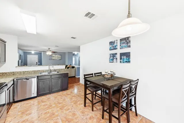 a kitchen with stainless steel appliances granite countertop a sink refrigerator and cabinets