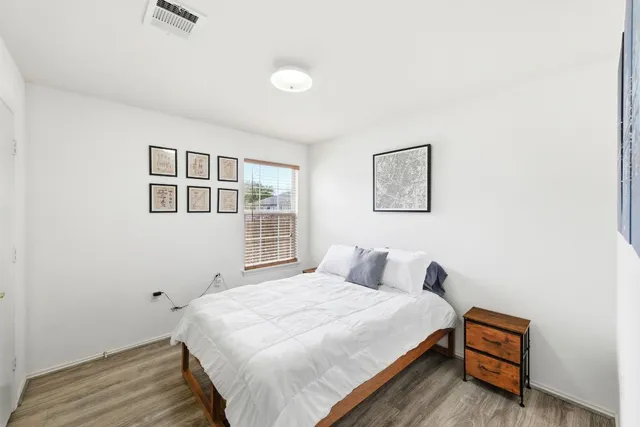 a bedroom with a bed lamps and a large window