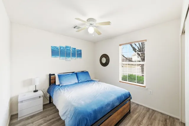 a bedroom with a large bed and a flat tv screen