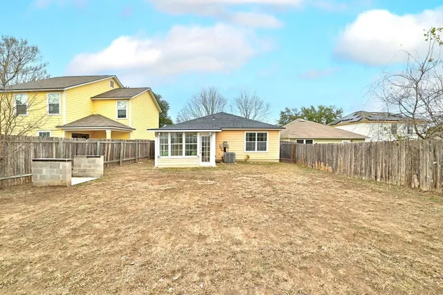 a view of backyard with wooden fence