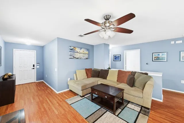 a living room with furniture and a wooden floor