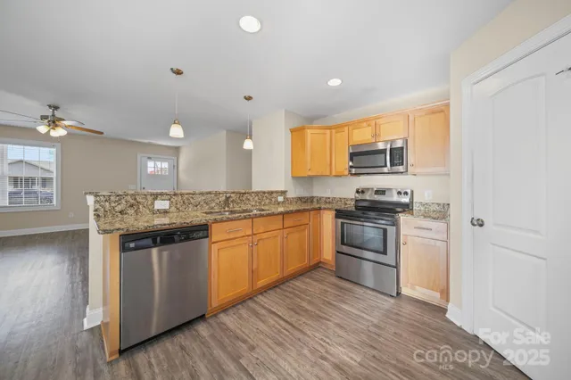 a kitchen with stainless steel appliances granite countertop a stove a sink and a microwave