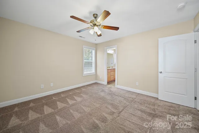 an empty room with closet and fan