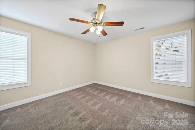an empty room with window and ceiling fan