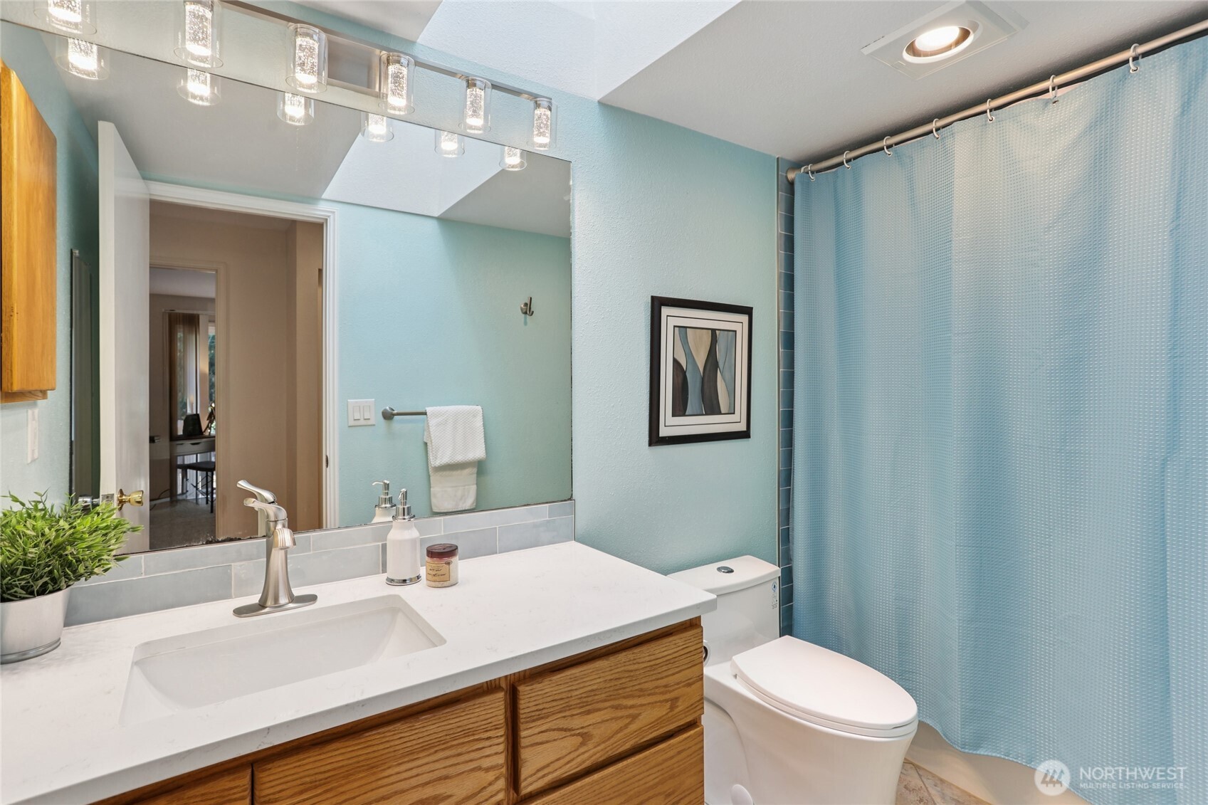 16535 147th Avenue Southeast Renton, WA 98058 - Photo 25 of 37 a bathroom with a sink a toilet a mirror and shower curtain