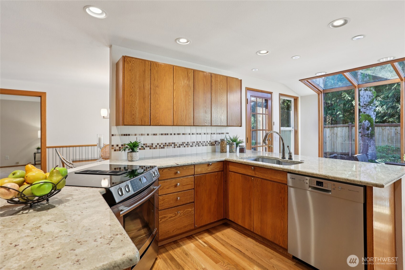 16535 147th Avenue Southeast Renton, WA 98058 - Photo 9 of 37 a kitchen with stainless steel appliances granite countertop wooden cabinets a stove a sink and a potted plant