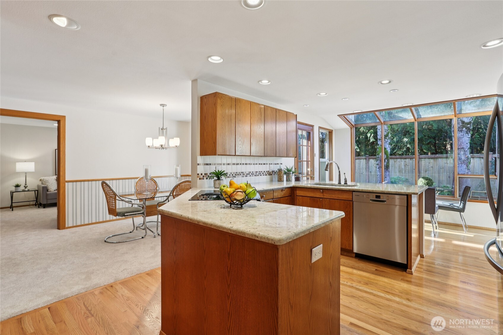 16535 147th Avenue Southeast Renton, WA 98058 - Photo 10 of 37 a kitchen with a stove a sink a counter top space and living room view