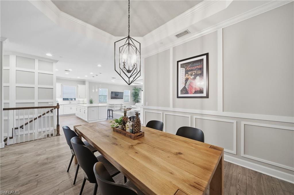 9658 Montelanico Loop, Unit 201 Naples, FL 34119 - Photo 15 of 46 a view of a dining room with furniture a chandelier and wooden floor