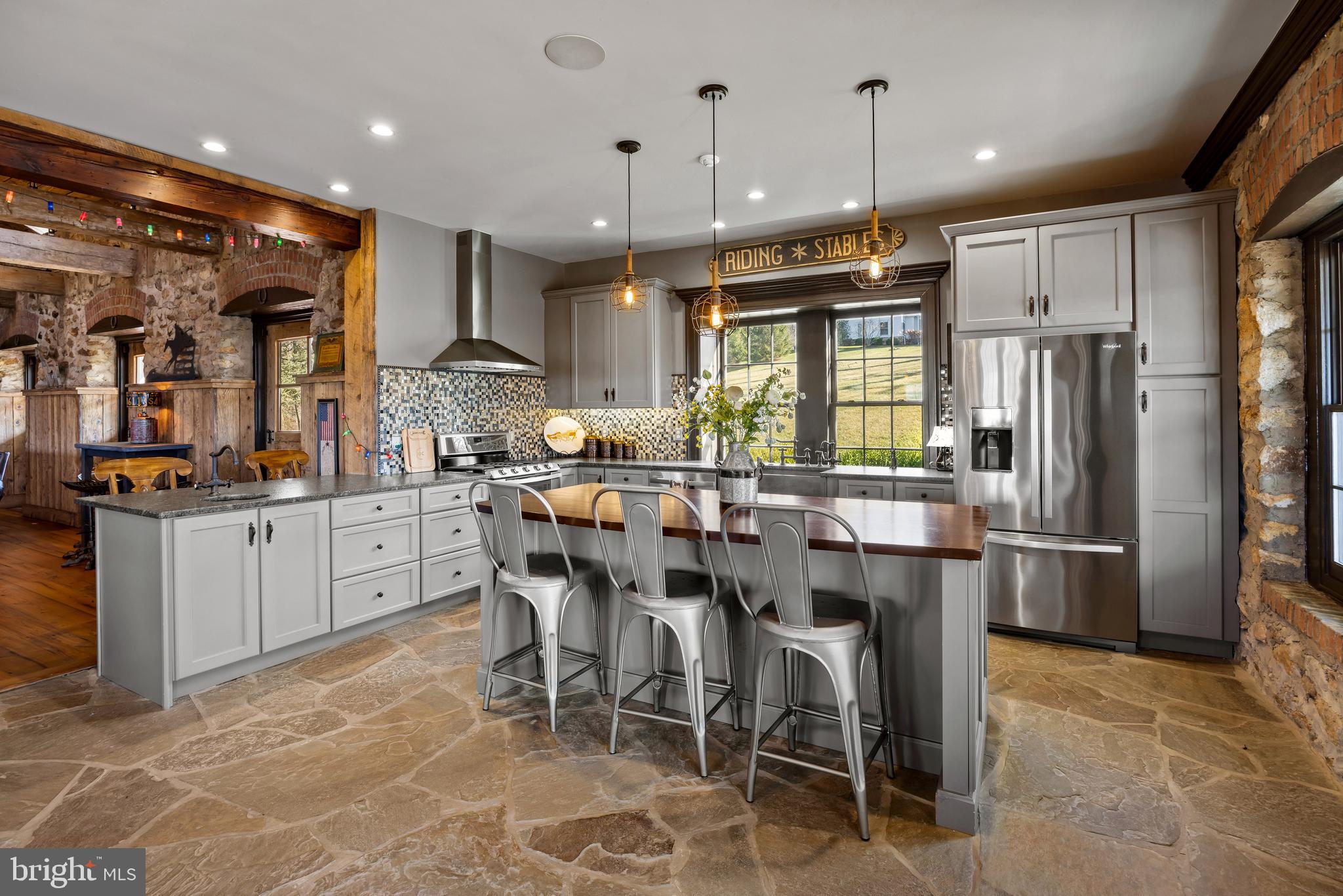 2734 Caves Road Owings Mills, MD 21117 - Photo 20 of 22 a kitchen with stainless steel appliances kitchen island granite countertop a table chairs and a refrigerator