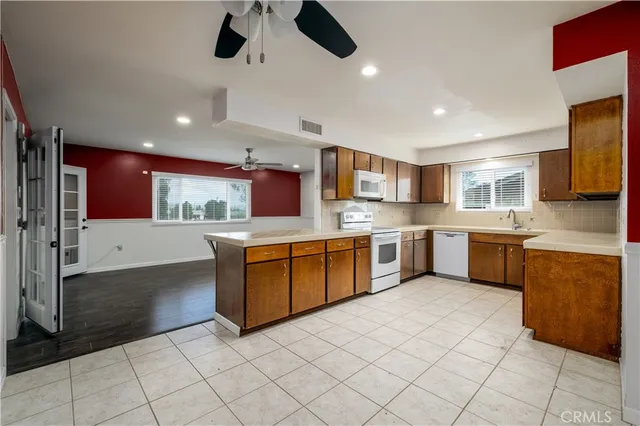 a large kitchen with stainless steel appliances kitchen island granite countertop a sink counter top space and cabinets
