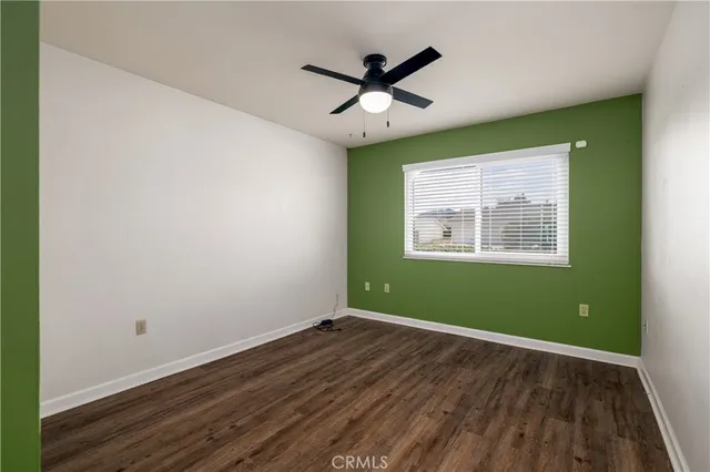 a view of a room with wooden floor and a ceiling fan